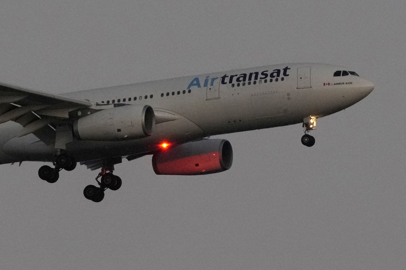 An Air Transat Airbus A330 approaches for landing in Lisbon just before sunrise, Monday, July 22, 2024. (AP Photo/Armando Franca)