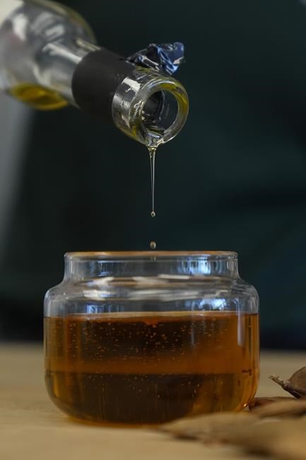 Ponova Oil is poured into a container at the Terviva headquarters in Alameda, Calif., Thursday, May 9, 2024. The oil, which is high in Omega 9 is made from the pongamia tree legume. The company has patented a process to remove the biopesticides from the pongamia tree legume that cause a bitter taste, making the bean suitable for food production. (AP Photo/Jeff Chiu)
