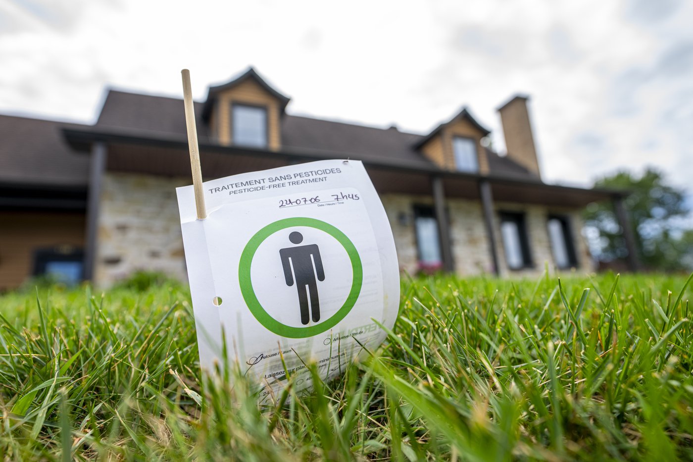 A sign indicating a lawn was treated without pesticides is displayed in front of a home in Granby, Que., on Thursday, July 23, 2026. THE CANADIAN PRESS/Christinne Muschi