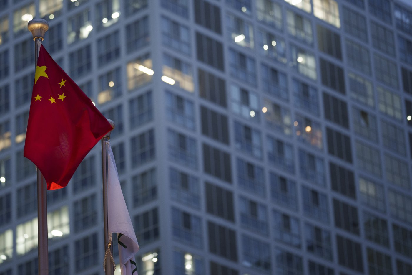 Chinese flag is on display during a ate evening with the background of central business district in Beijing, China, Monday, July 15, 2024. (AP Photo/Vincent Thian)