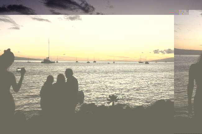 Tourists take photos near the water on a reopened area of Front Street, Friday, July 5, 2024, in Lahaina, Hawaii. Cleanup and rebuilding efforts continue after the 2023 wildfire that killed over 102 people and destroyed the historic town of Lahaina on the island of Maui. (AP Photo/Lindsey Wasson)