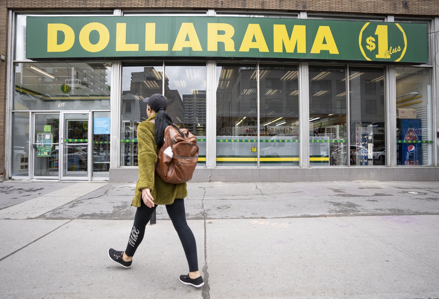 A person walks past a Dollarama store in Montreal, Wednesday, June 7, 2023. THE CANADIAN PRESS/Christinne Muschi