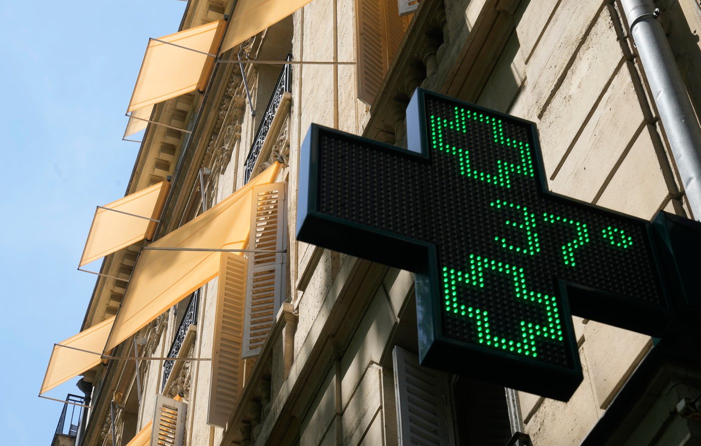 A sign outside a pharmacy displays a temperature of 37 degrees Celsius (98.6 degrees Fahrenheit) in Paris, Sunday, June 21, 2026.