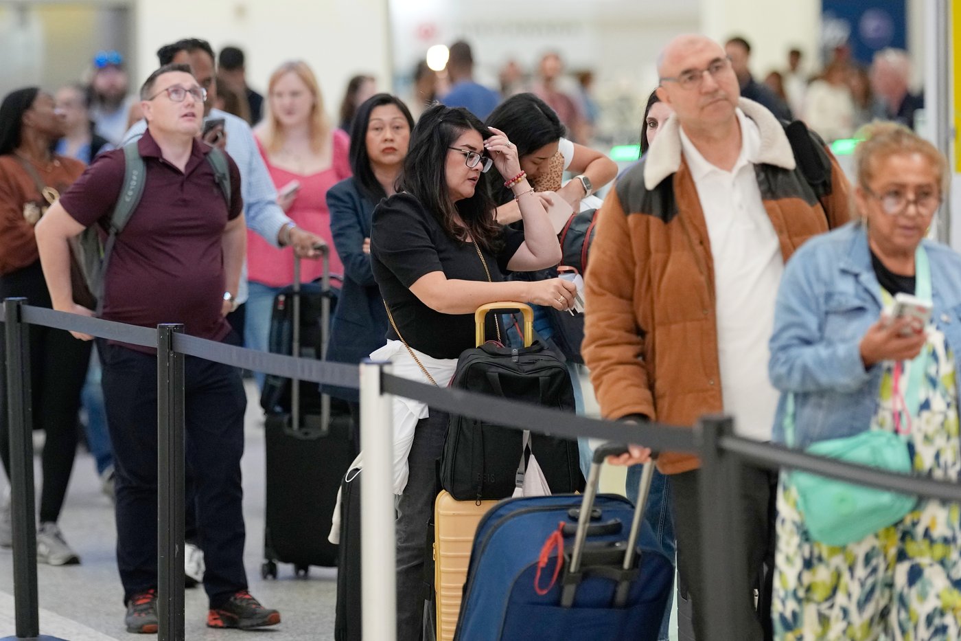 Passengers wait in a security checkpoint line at George Bush Intercontinental Airport, Wednesday, March 25, 2026, in Houston. (AP Photo/David J. Phillip)