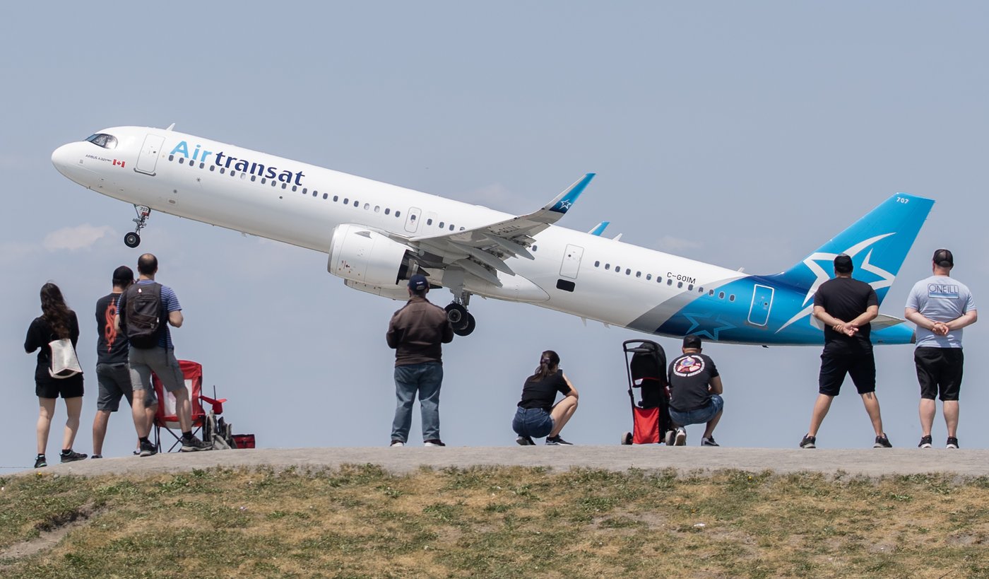 People look on as an Air Transat plane takes off at Pierre Elliott Trudeau International Airport in Montreal, Sunday, June 11, 2023. THE CANADIAN PRESS/Graham Hughes