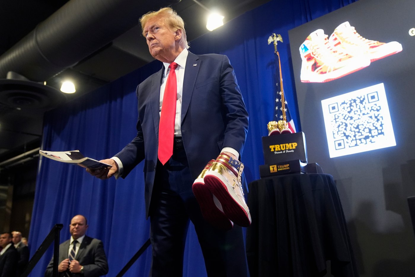 FILE - Donald Trump hold a Playboy magazine and gold Trump sneakers at Sneaker Con Philadelphia, an event popular among sneaker collectors, in Philadelphia, Saturday, Feb. 17, 2024. (AP Photo/Manuel Balce Ceneta, File)