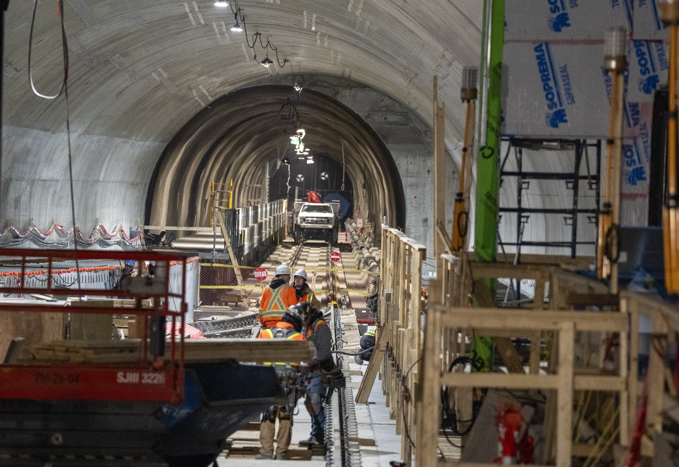 Construction workers are seen on the tracks on the platform level for the Reseau express metropolitain (REM) electric light rail system at Montreal-Pierre Elliott Trudeau International Airport in Montreal on Wednesday, April 8, 2026. THE CANADIAN PRESS/Christinne Muschi