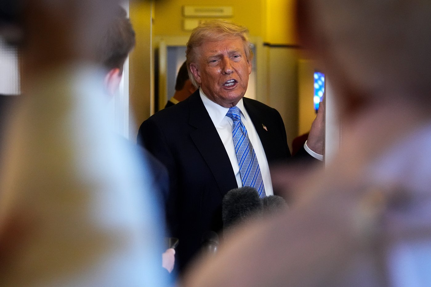 President Donald Trump speaks to reporters aboard Air Force One, Friday, May 15, 2026, as he returns from a trip to Beijing, China. (AP Photo/Mark Schiefelbein)