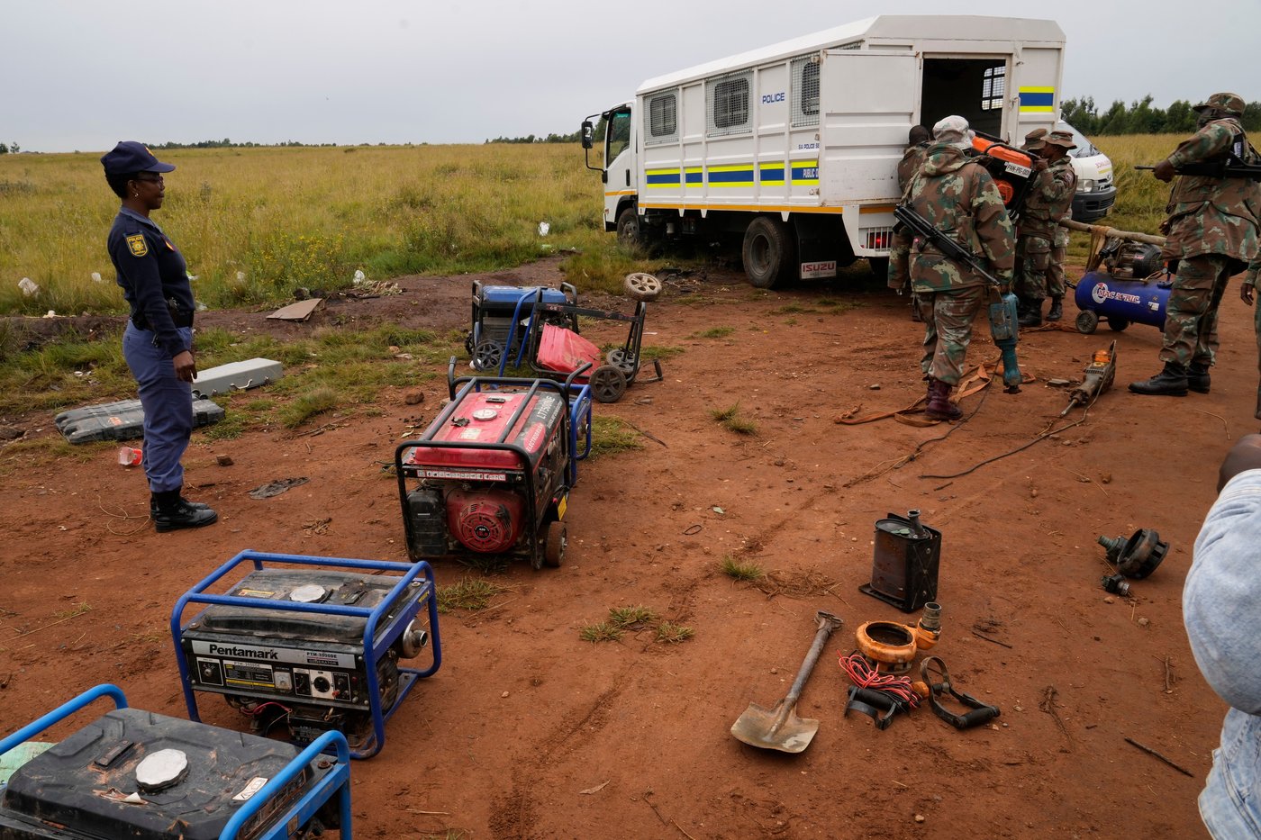 South African National Defense Force soldiers and police officers load recovered generators and machinery left behind by illegal miners, during a patrol in Randfontein, west of Johannesburg, South Africa, Thursday, March 12, 2026. (AP Photo/Themba Hadebe)