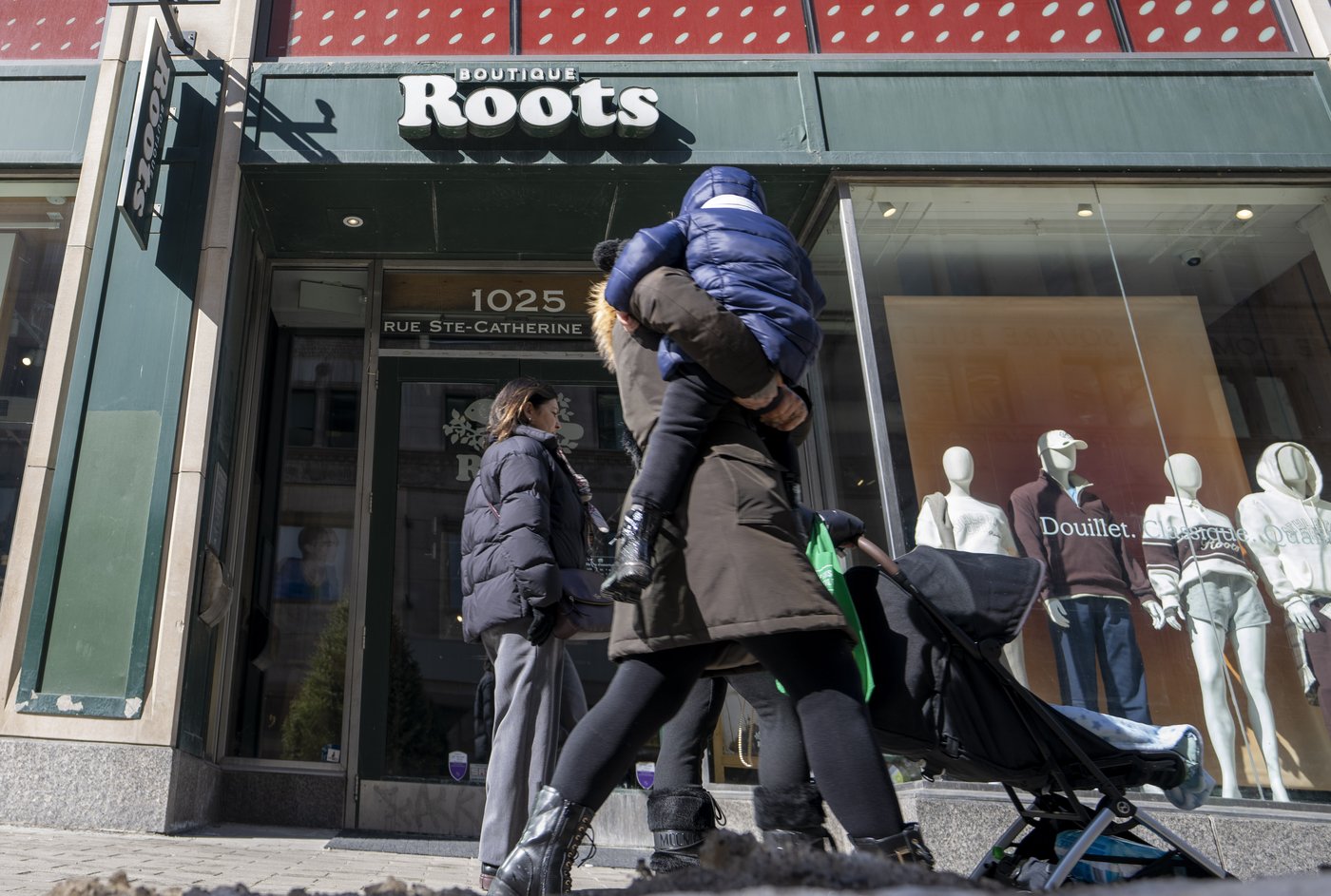 People walk past a Roots Canada store in Montreal on Wednesday, March 4, 2026. THE CANADIAN PRESS/Christinne Muschi