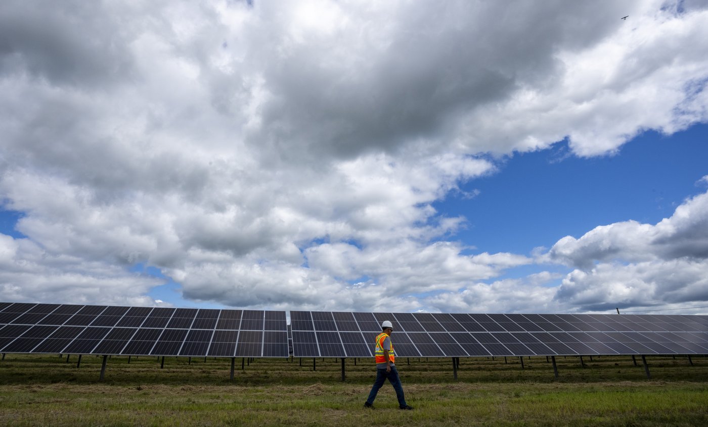 A Hydro-Québec employee walks past monofacial solar panels installed on the 5.6 hectares at the Robert-A.-Boyd Solar Power Plant in Varennes, Que., on Monday, July 21, 2025. THE CANADIAN PRESS/Christinne Muschi