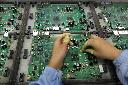 A Celestica employee works on a motherboard at the Celestica Technology Co. Ltd, a Canada-based electronics company, in China's southern city, Dongguan, Wednesday, July 29, 2009. (AP Photo/Vincent Yu)