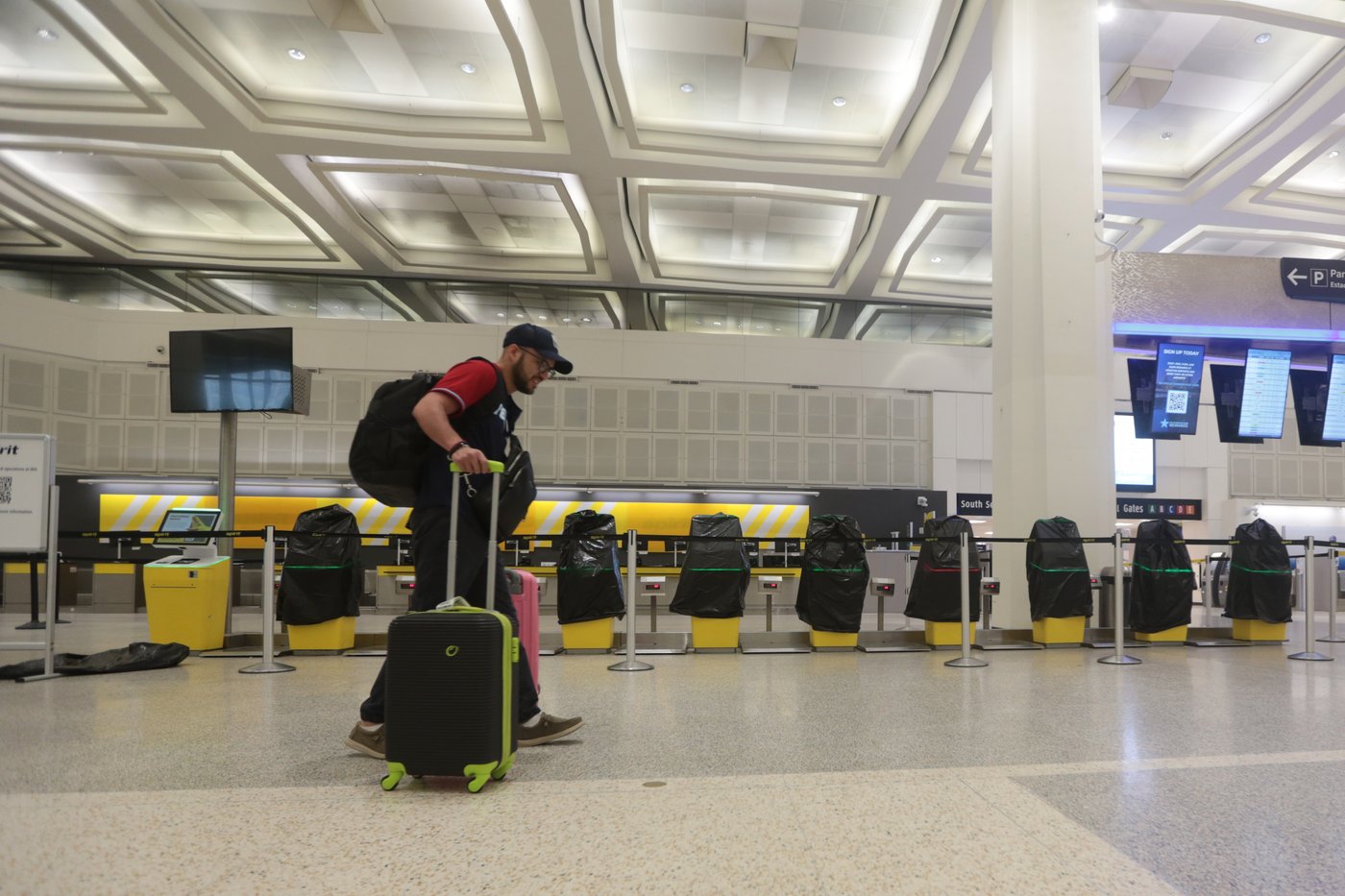 A traveler walks past covered Spirit Airlines kiosks, Saturday, May 2, 2026, at George Bush Intercontinental Airport, in Houston. (AP Photo/Lekan Oyekanmi)