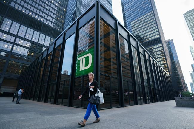 A person walks past a TD Bank sign in the financial district in Toronto on Tuesday, Sept. 20, 2022. TD Bank Group says its direct deposit system has been hit by technical issue that is preventing account holders from getting paid. THE CANADIAN PRESS/Alex Lupul
