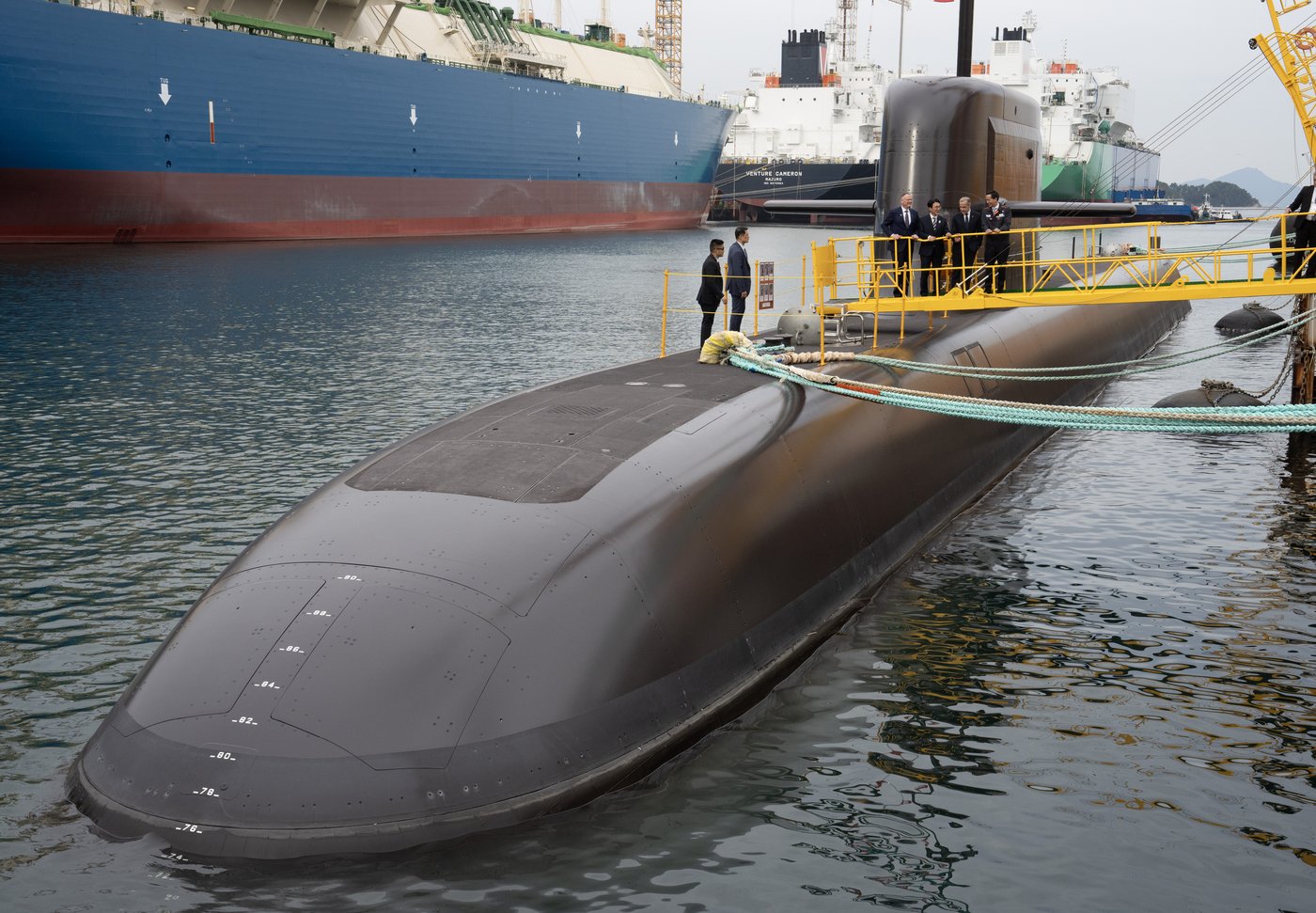 National Defence Minister David McGuinty, back left to right, South Korea Prime Minister Kim Min-seok, Prime Minister Mark Carney and Hahnwa Group Vice-Chariman Kim Dong Kwan speak amongst themselves after touring a submarine at the Hanwha Ocean Shipyard in Geoje Island, South Korea, Thursday Oct. 30, 2025. THE CANADIAN PRESS/Adrian Wyld