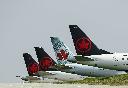 Grounded Air Canada planes sit on the tarmac at Pearson International Airport during the COVID-19 pandemic in Toronto on Wednesday, April 28, 2021. An arbitrator has ordered Air Canada to grant back pay to seven pilots denied religious exemptions from the airline's mandatory COVID-19 vaccination policy. THE CANADIAN PRESS/Nathan Denette