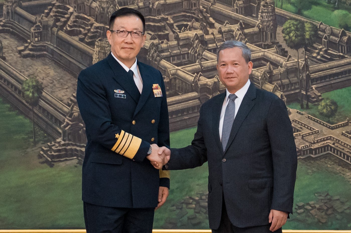 In this photo released by Agence Kampuchea Press (AKP), Chinese Defense Minister Dong Jun, left, shakes hands with Cambodian Prime Minister Hun Manet prior to a meeting at Peace Palace in Phnom Penh, Cambodia, Wednesday, April 22, 2026. (Heng Sinith/AKP via AP)