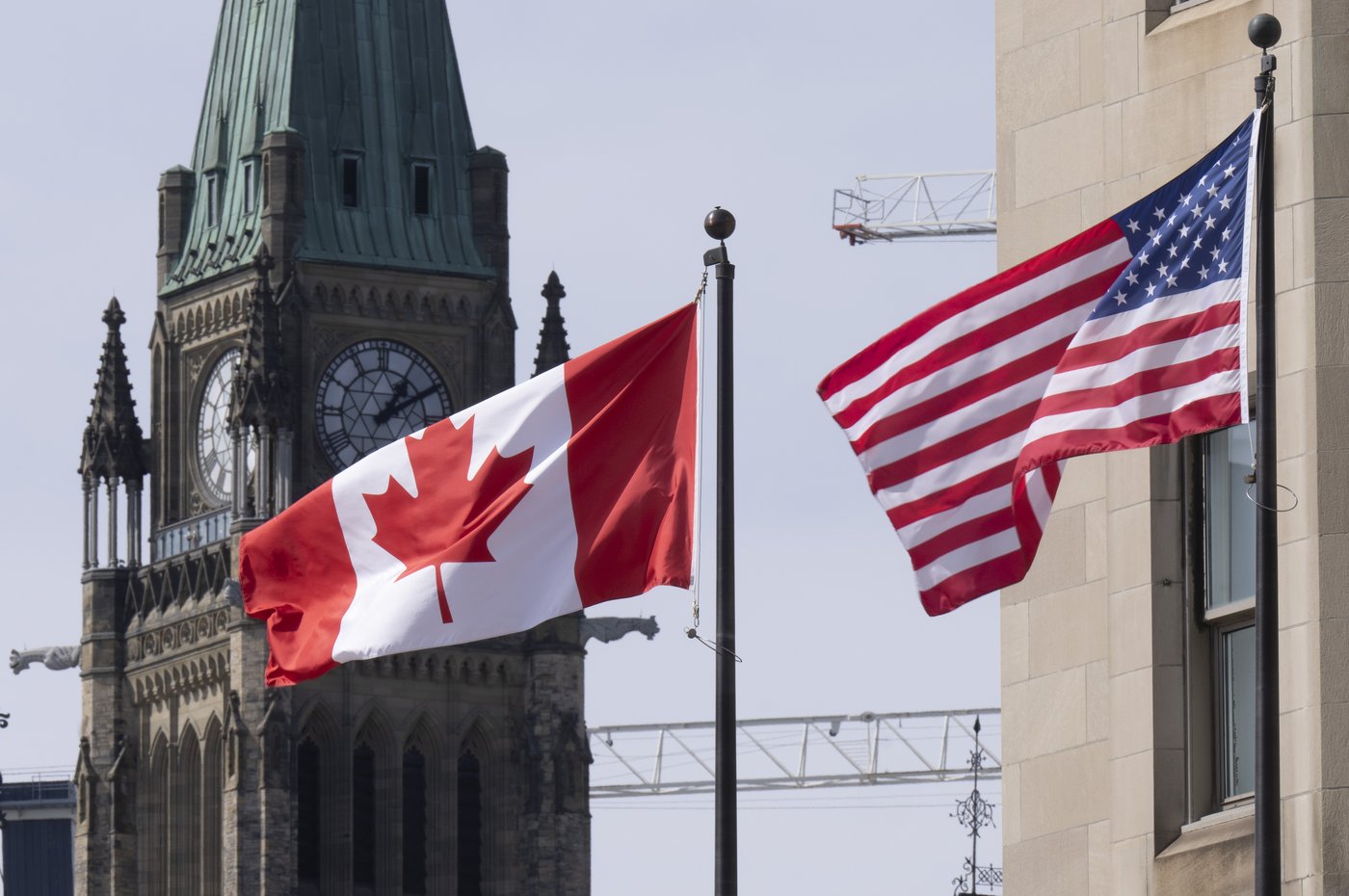 Canadian and United States flags are seen flying near Parliament Hill, Wednesday, March 22, 2023 in Ottawa. THE CANADIAN PRESS/Adrian Wyld