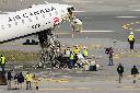 Officials inspect the wreckage of an Air Canada Express jet, Wednesday, March 25, 2026, just off the runway where it had collided with a Port Authority fire truck Sunday night at LaGuardia Airport in New York. (AP Photo/Yuki Iwamura)