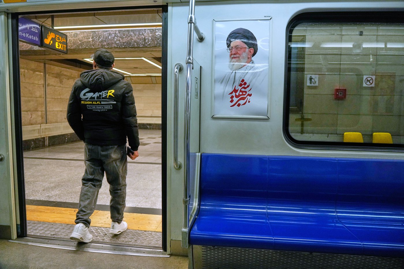 A man leaves a subway train past an image of the late Iranian Supreme Leader Ayatollah Ali Khamenei, in Tehran, Iran, Friday, March 13, 2026. (AP Photo/Vahid Salemi)