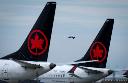 Air Canada aircraft sit parked at Vancouver International Airport as a United Airlines flight from Chicago prepares to land, in Richmond, B.C., on Monday, Aug. 18, 2025. THE CANADIAN PRESS/Darryl Dyck