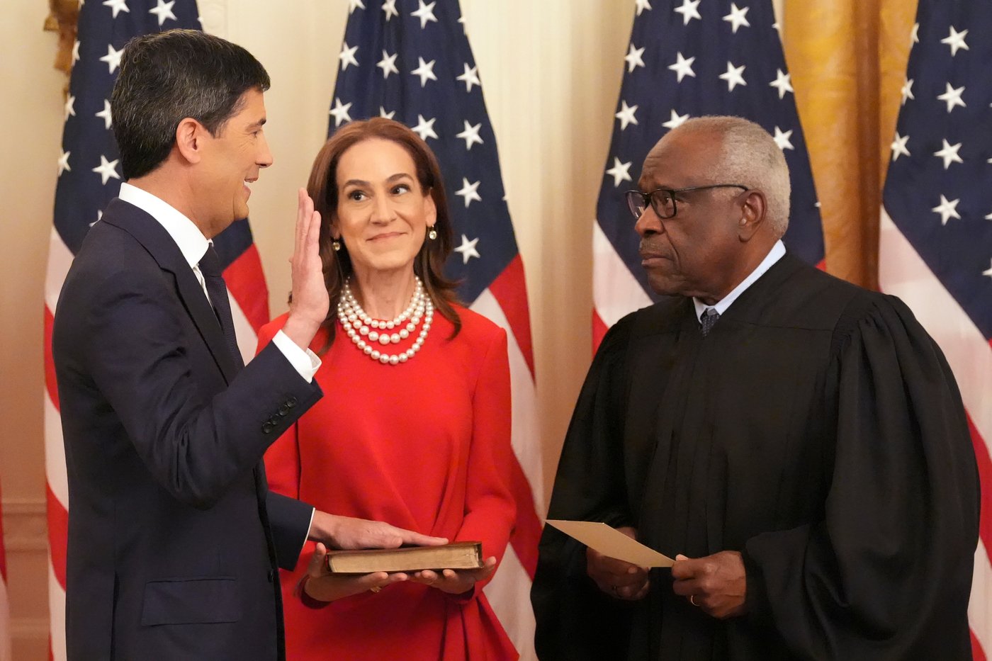 Justice Clarence Thomas, right, administers the oath during the swearing in of Kevin Warsh as Chairman of the Federal Reserve, left, as Warsh's wife Jane Lauder looks on, in the East Room of the White House, Friday, May 22, 2026, in Washington. (AP Photo/Alex Brandon)