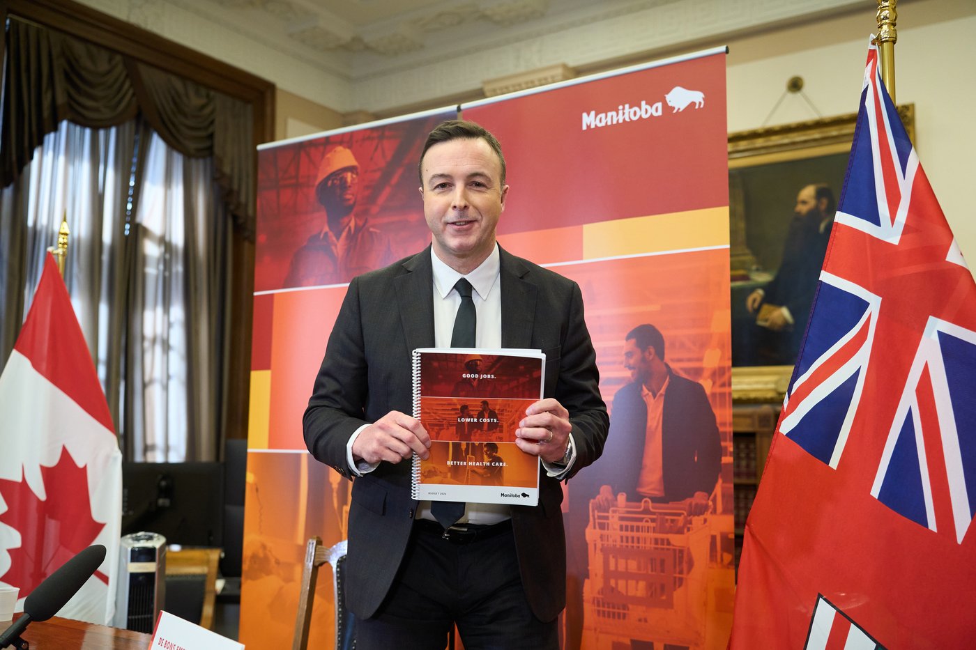 Manitoba Finance Minister Adrien Sala poses with the provincial budget after speaking to the media at the legislature in Winnipeg, on Tuesday, March 24, 2026. THE CANADIAN PRESS/David Lipnowski