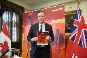 Manitoba Finance Minister Adrien Sala poses with the provincial budget after speaking to the media at the legislature in Winnipeg, on Tuesday, March 24, 2026. THE CANADIAN PRESS/David Lipnowski