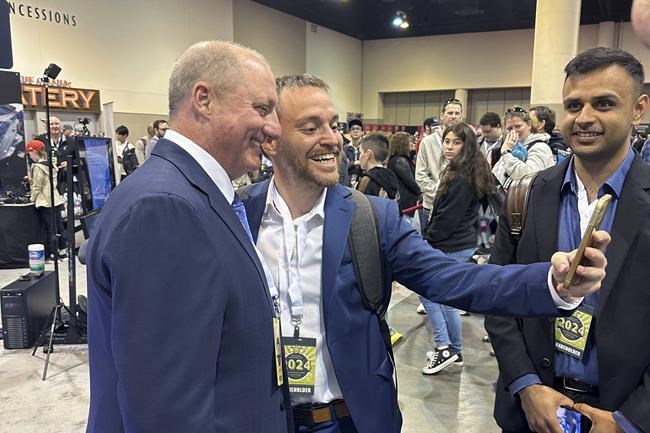 Berkshire Hathaway shareholders line up to take selfies with Greg Abel Friday, May 3, 2024, in Omaha, Neb. Abel will one day replace Warren Buffett as CEO. (AP Photo/Josh Funk)
