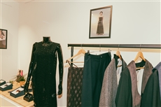 A mannequin in a room with clothes on swingersDescription automatically generated