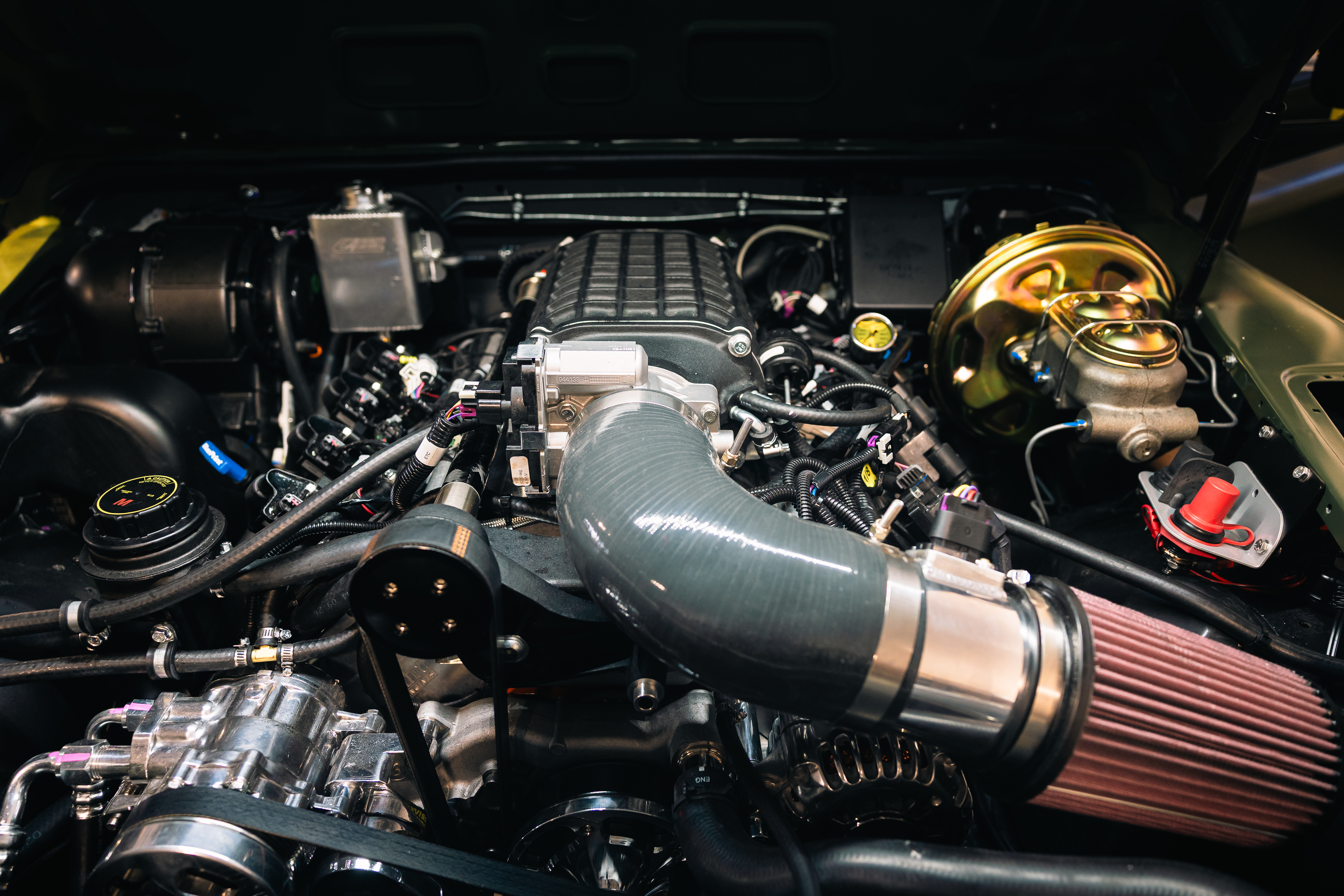 Close-up view of ECD's 700+HP BLUEPRINT V8 engine installed in a custom Defender, featuring supercharger assembly and performance intake system