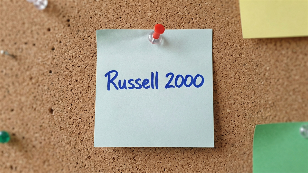 Sticky note labeled “Russell 2000” pinned on corkboard, symbolizing small-cap stock market performance and investor focus.