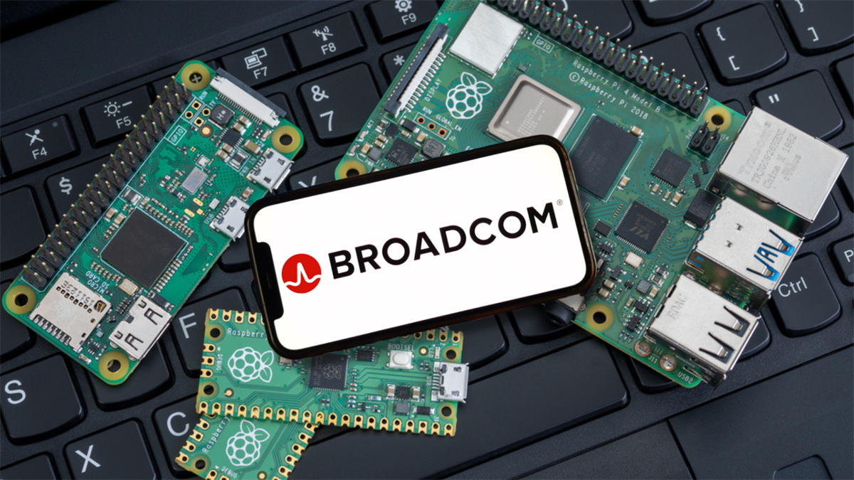 Broadcom logo displayed on a smartphone screen surrounded by Raspberry Pi circuit boards on a laptop keyboard.