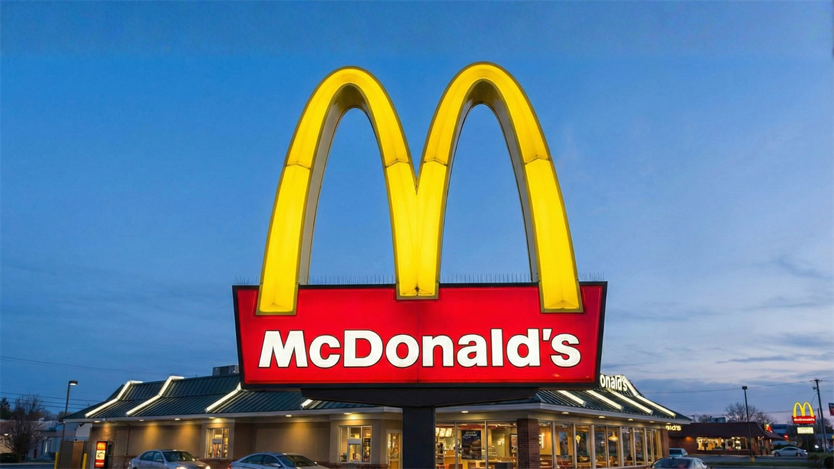 McDonald’s golden arches sign lit up outside a restaurant at dusk, highlighting the brand’s defensive strength theme.