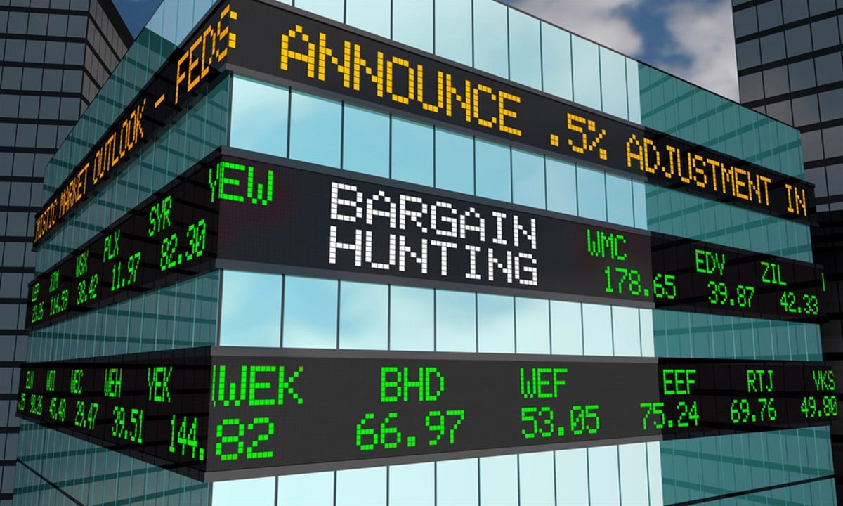 Photo of stock ticker on a building that says Bargain Hunting scrolling across amid stock prices.