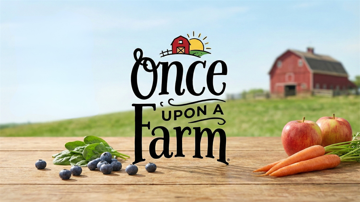 Once Upon a Farm logo over a wooden table with fresh blueberries, spinach, apples, and carrots, with a barn in the background.