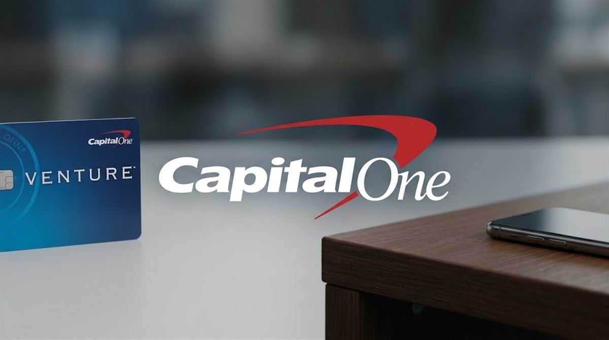 Capital One logo displayed alongside a Capital One Venture credit card on a desk.