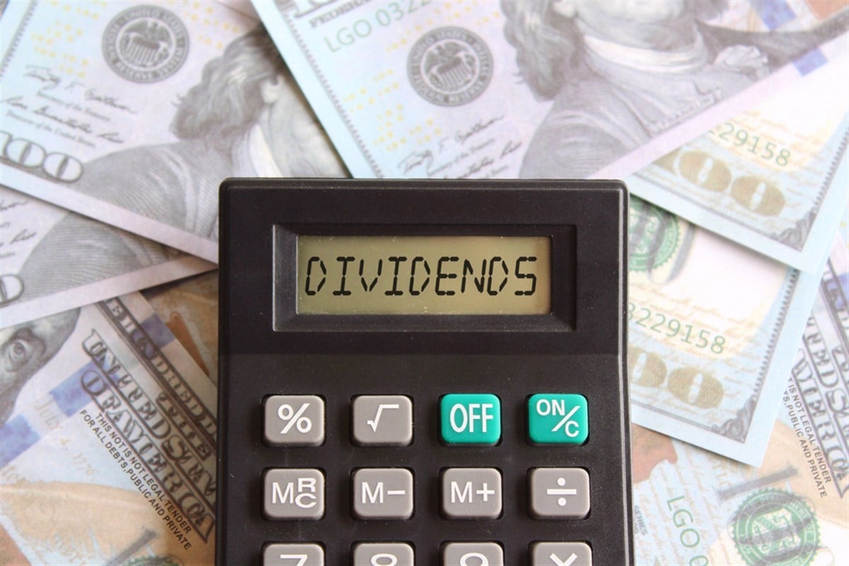 Top view image of calculator with text DIVIDENDS and money. Business and finance concept — Photo