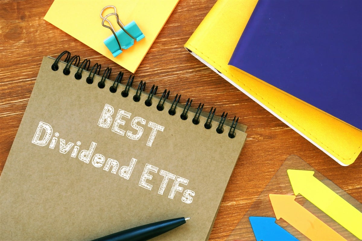 Best Dividend ETFs notebook on desk alongside colorful arrows and office supplies.