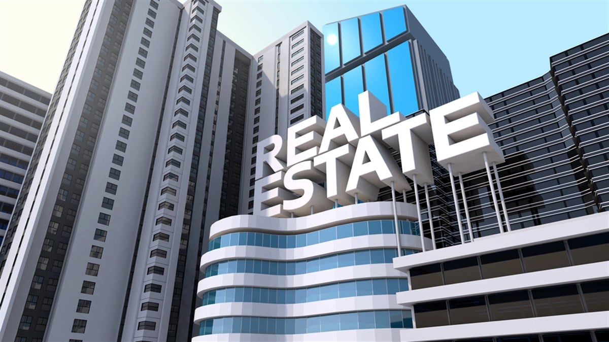 The words "real estate" rest atop a skyscraper.