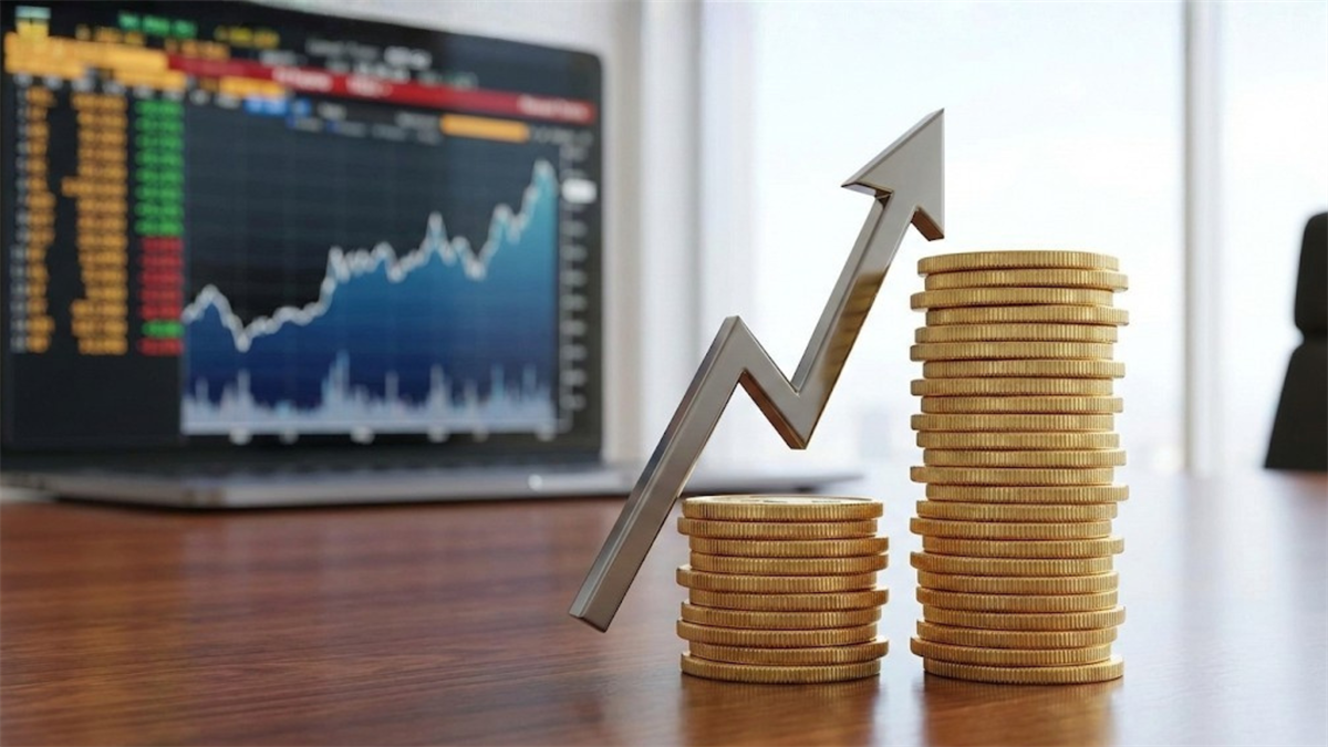 Stacks of coins with an upward arrow beside a stock screen, signaling a dividend increase and rising returns.