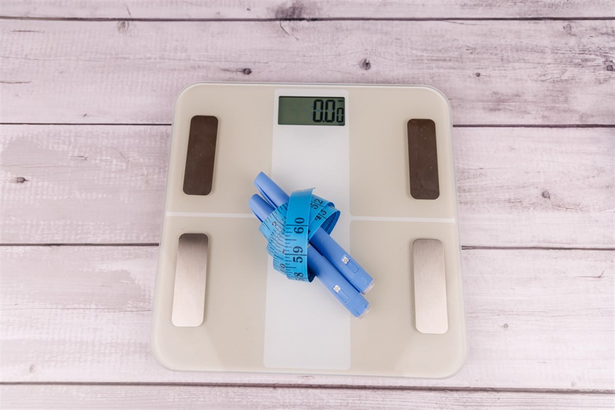 Medical weight management: Digital scale, Ozempic pens, and measuring tape on white table — Photo