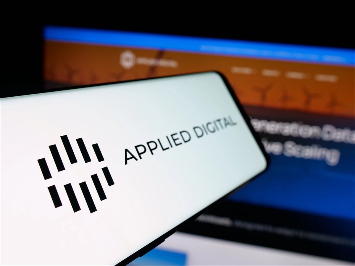 Applied Digital logo displayed on smartphone with company homepage in background.
