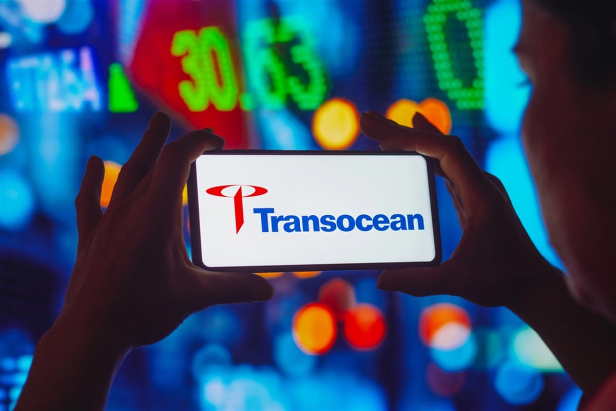 the transocean logo is displayed on a smartphone screen, with stock market tickers in the background