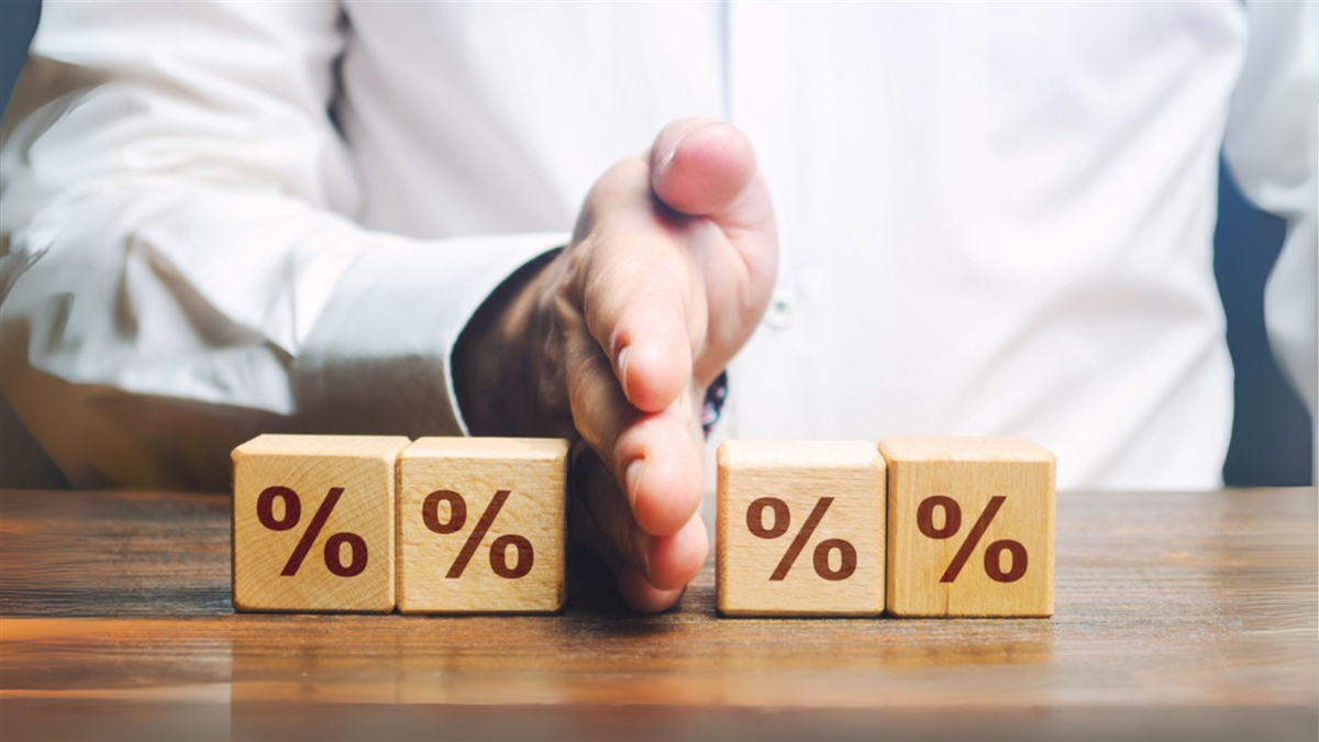man's hand separating blocks with % signs on them indicating a rate cut