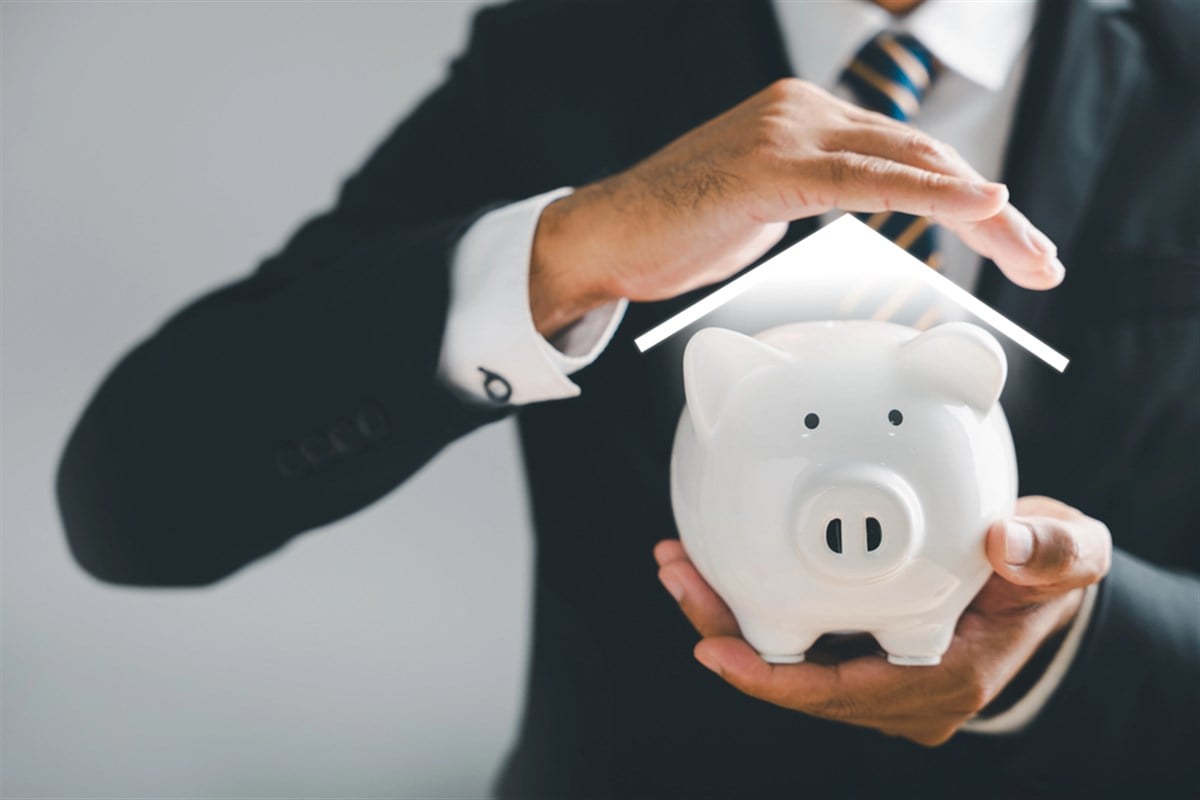 Protecting your money, man hand shields protection piggy bank. trust and assurance concept. ensuring wealth safety with insurance. business, finance, and income safeguarded.