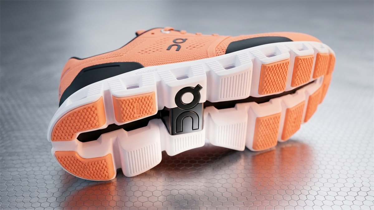 Close-up of orange On running shoe sole with logo.