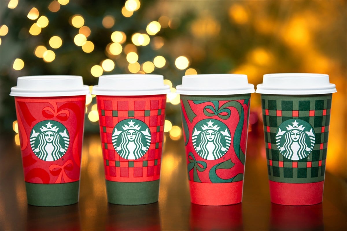 Starbucks holiday cups displayed with festive lights highlight seasonal product demand amid the company’s ongoing turnaround strategy.