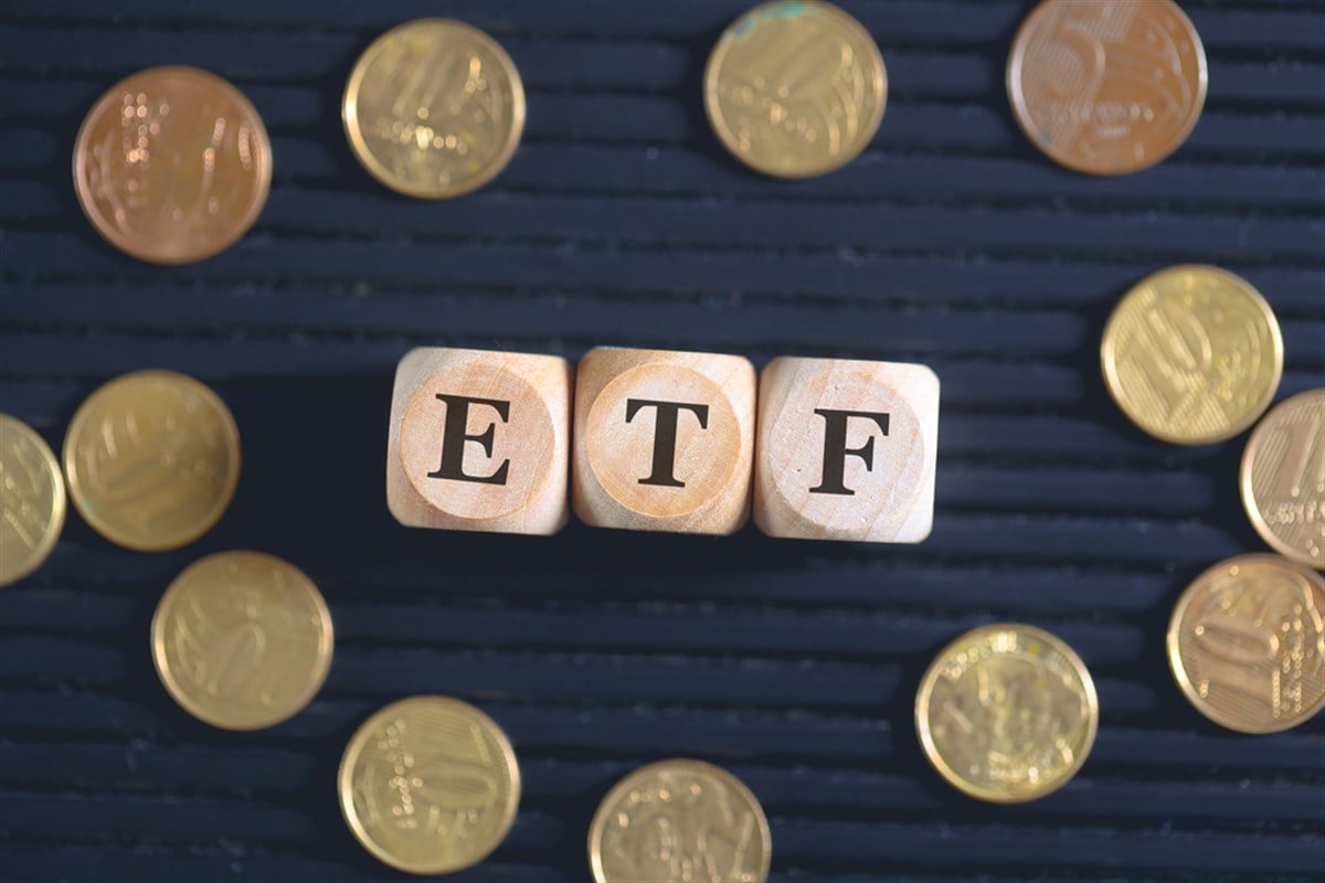 ETF acronym for Exchange Traded Fund written on wooden cubes and coins on black background. — Photo