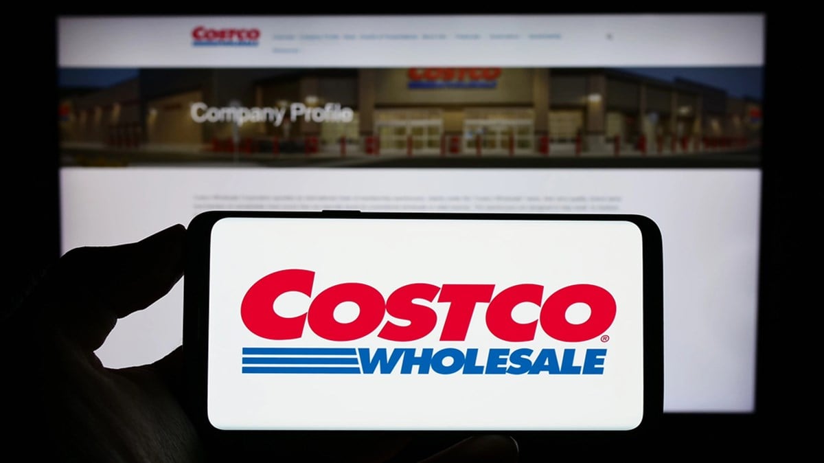 Costco logo in front of Costco homepage on desktop computer.